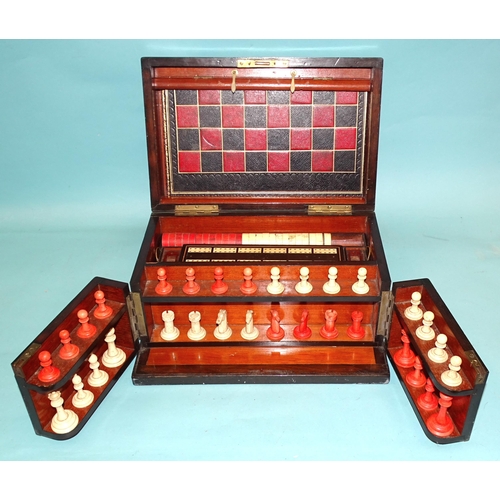 75 - A Victorian walnut games compendium fitted with games board, bone draughts, chess pieces and dominoe... 