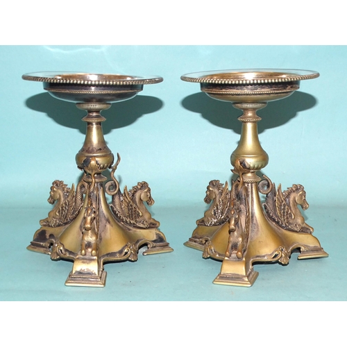 78 - A pair of metal tazza stands, each triform base with three winged horse supports, 18cm high, (platin... 