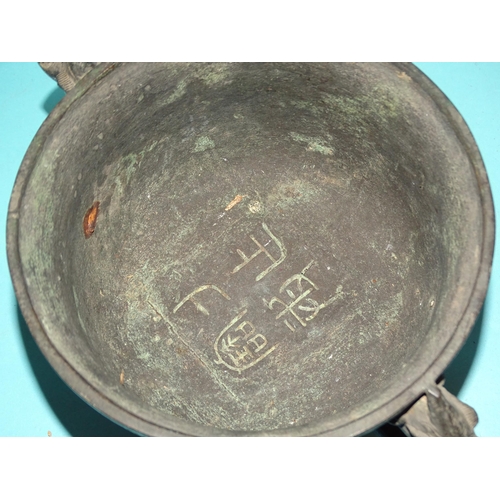 82 - An Asian bronze bowl of Indo-Chinese style, 23cm diameter and a later metal hand bell, (2).... 