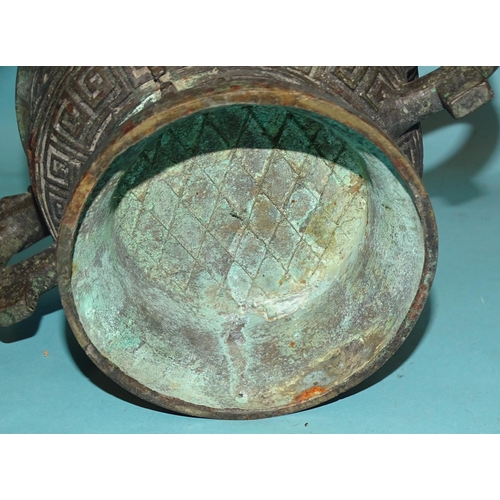 82 - An Asian bronze bowl of Indo-Chinese style, 23cm diameter and a later metal hand bell, (2).... 