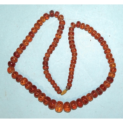 403 - A necklace of graduated and faceted honey-coloured amber beads, 50g.