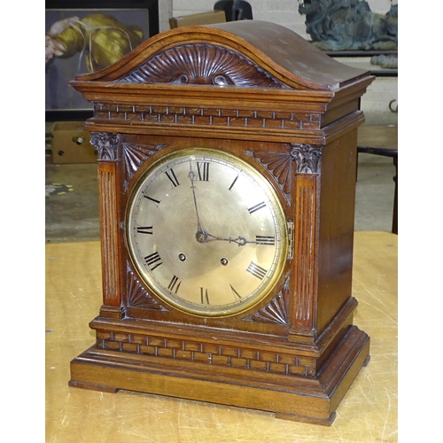 54 - An early-20th century walnut mantel clock with architectural-form case, convex silvered dial and twi... 