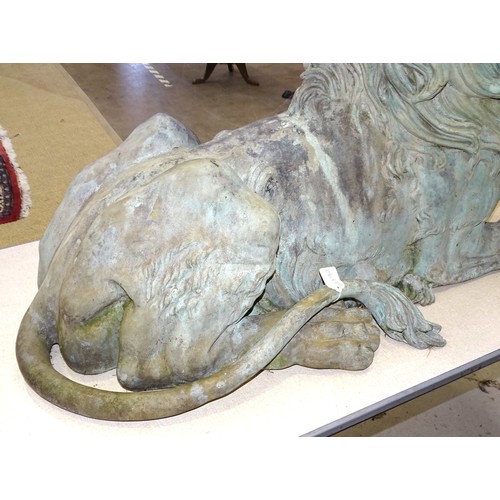 86 - An impressive and large pair of cast metal and coppered lions, each recumbent lion with open mouth, ... 