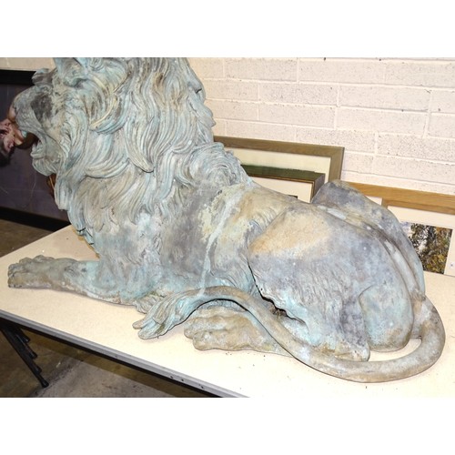 86 - An impressive and large pair of cast metal and coppered lions, each recumbent lion with open mouth, ... 