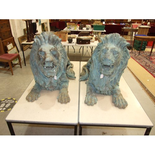 86 - An impressive and large pair of cast metal and coppered lions, each recumbent lion with open mouth, ... 