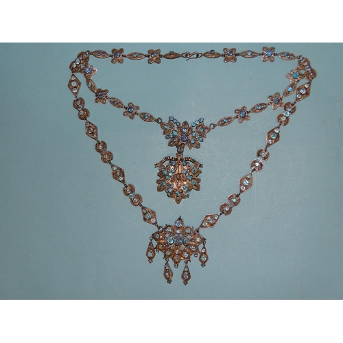 128 - A white metal filigree necklace with locket-back pendant, set overall with blue paste stones.... 