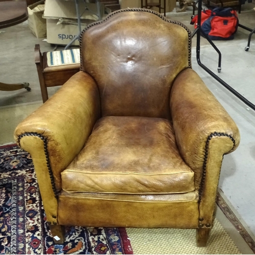 2 - A brown leather upholstered deep-seated club armchair with studded detail.