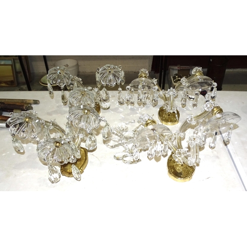 73 - A pair of modern crystal and brass three-branch wall lights with drops, 18cm high, together with ano... 