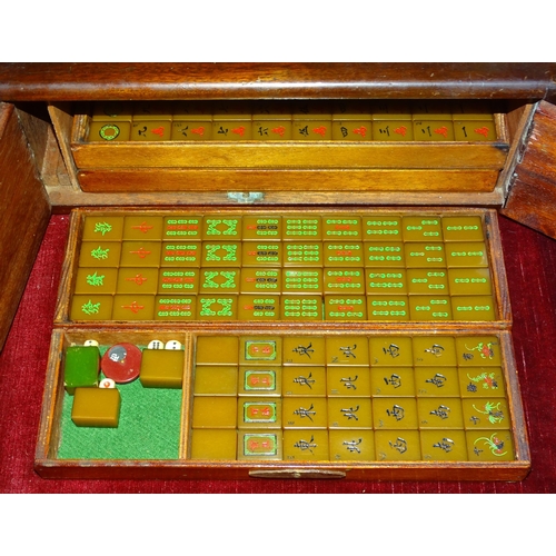 66 - A Mahjong set with two-toned Bakelite tiles, contained in four drawers and fitted cabinet, including... 