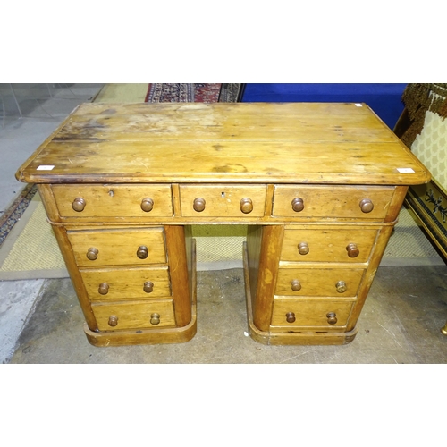 6 - An antique pine knee-hole desk having an arrangement of nine pedestal drawers, 110 x 75cm.... 