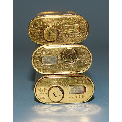 524 - A Cartier engine-turned gilt metal cigarette lighter with red band around the flip lid, serial no.29... 