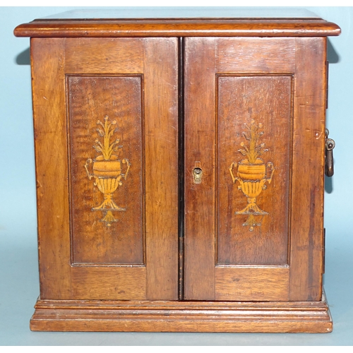 212 - A mahogany coin collectors cabinet fitted with a pair of hinged doors with inlaid vase decoration op... 