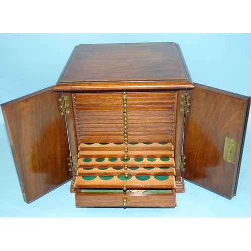 212 - A mahogany coin collectors cabinet fitted with a pair of hinged doors with inlaid vase decoration op... 