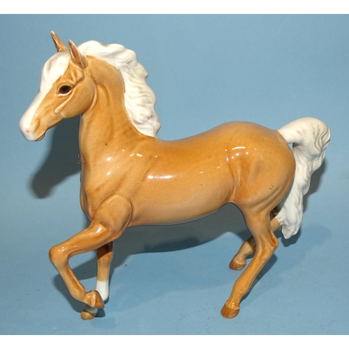 28 - A Beswick Highland pony, dun gloss, 18cm high, a Palomino (prancing Arab type) horse, 17cm high, a S... 