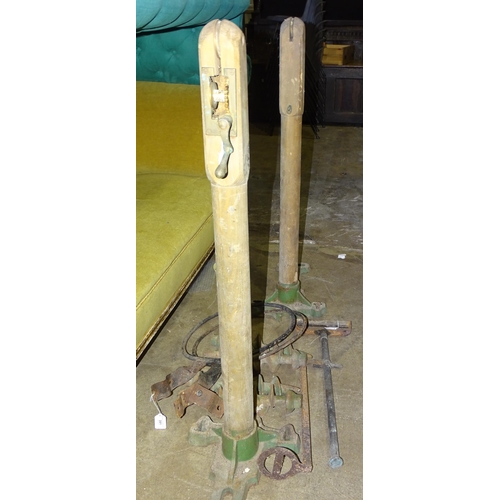 82 - A pair of 20th century wood and cast-iron tennis net posts, the cast bases marked 