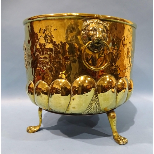 105 - A 20th century circular brass embossed log box with lion mask handle, 41cm diameter, 36cm high.... 