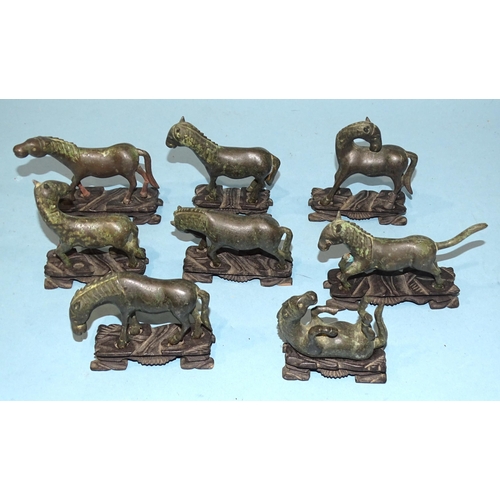 138 - A collection of eight Oriental bronze models of horses, on carved wood bases, (8).