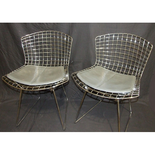 27 - A pair of side chairs designed by Harry Bertoia, the chrome plated frames with grey leather seat pad... 