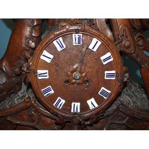 91 - A large and impressive carved wood Black Forest clock, the circular dial with enamelled numerals and... 