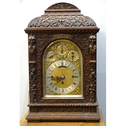 94 - An early-20th century musical bracket clock, the heavily-carved oak domed case with arched door and ... 