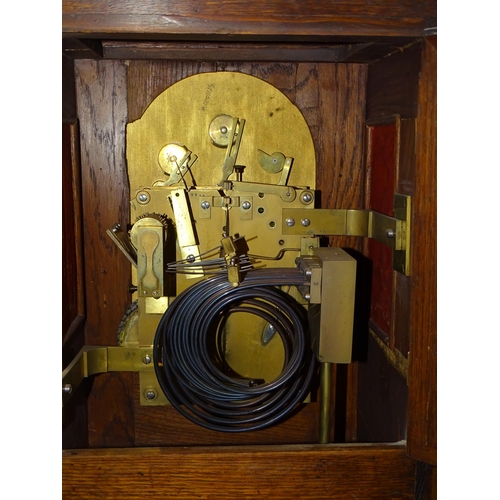 94 - An early-20th century musical bracket clock, the heavily-carved oak domed case with arched door and ... 