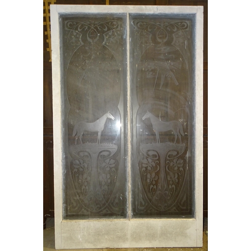 22 - *An early-20th century saloon-style door of two glass panels etched with a meat cleaver suspended ab... 