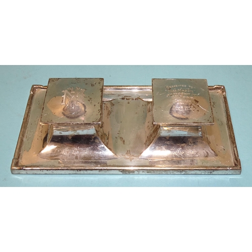 512 - A George V silver inkstand of rectangular form, on loaded base, fitted with two hinged lidded inkwel... 