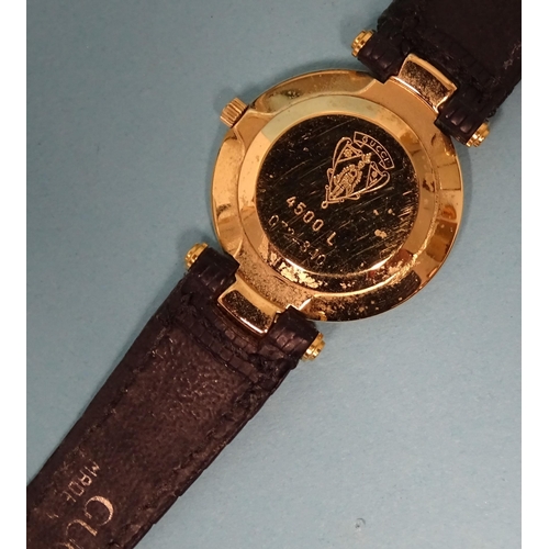 687 - Gucci, a lady's gold-plated wrist watch with black dial and quartz movement, on leather strap, (in o... 