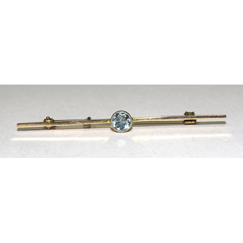 897 - An Edwardian 9ct gold bar brooch millegrain-set a round-cut aquamarine, 58mm wide, 3g.... 