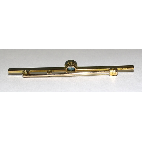 897 - An Edwardian 9ct gold bar brooch millegrain-set a round-cut aquamarine, 58mm wide, 3g.... 