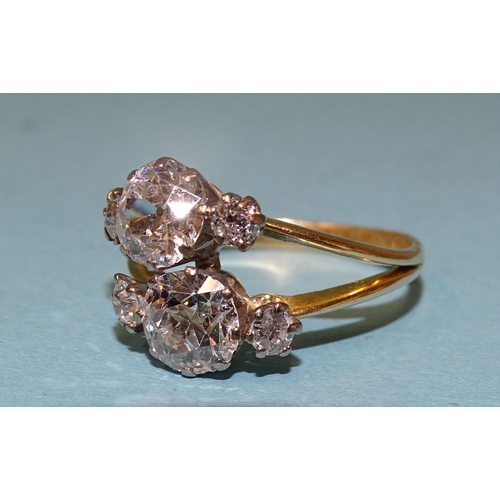 927 - A diamond ring asymmetrically-claw-set two old brilliant-cut diamonds, one approximately 1.29cts, th... 