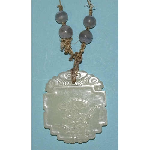 799 - A Chinese celadon jade and blue agate necklace, the pendant of shaped oval form, carved in low relie... 