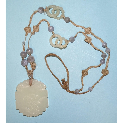 799 - A Chinese celadon jade and blue agate necklace, the pendant of shaped oval form, carved in low relie... 