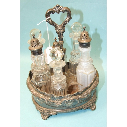 551 - A Victorian silver and glass cruet stand of oval outline with embossed foliate and scroll decoration... 