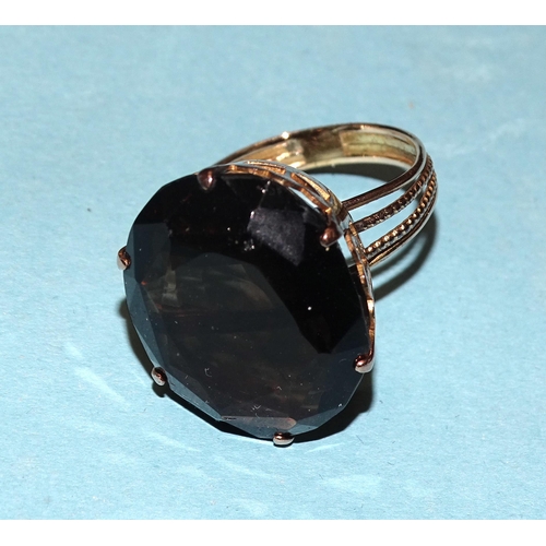 829 - A dress ring claw-set a large oval smoky quartz, in unmarked yellow metal mount, size Q½, 8.5... 