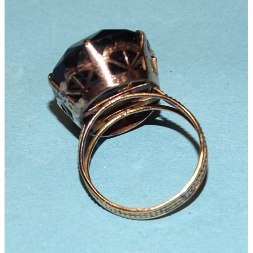 829 - A dress ring claw-set a large oval smoky quartz, in unmarked yellow metal mount, size Q½, 8.5... 