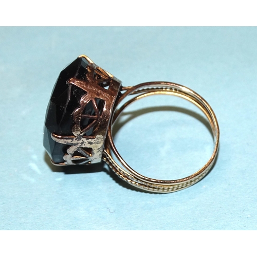 829 - A dress ring claw-set a large oval smoky quartz, in unmarked yellow metal mount, size Q½, 8.5... 