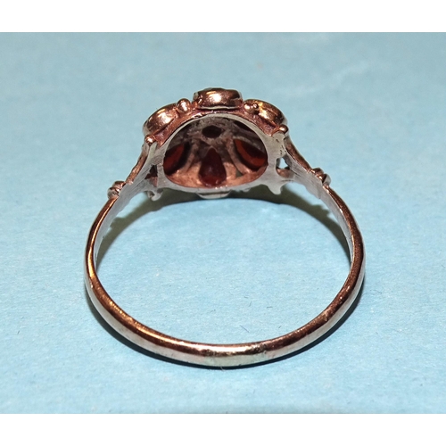 832 - A garnet daisy cluster ring with 9ct gold mount, size P½, 2.4g.