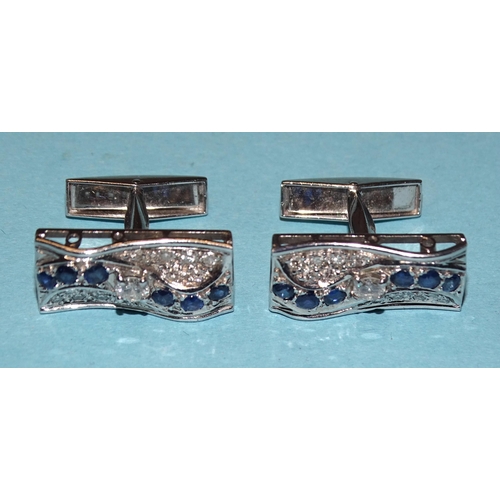 852 - A pair of 18ct white gold cufflinks, each set a wavy line of six round-cut sapphires and one brillia... 