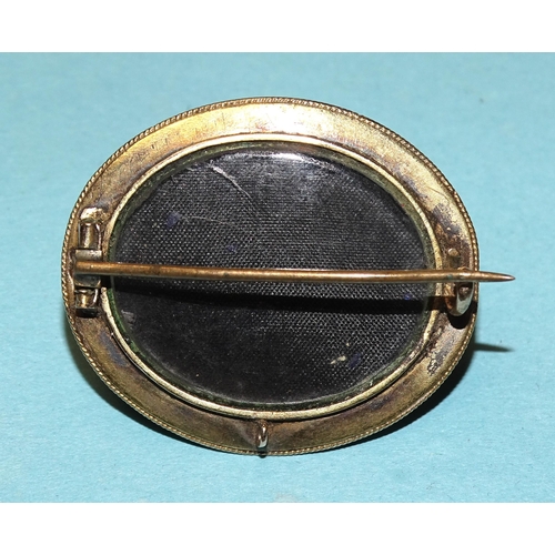 855 - A Victorian mourning brooch set oval onyx cabochon within black enamelled border, with locket back, ... 