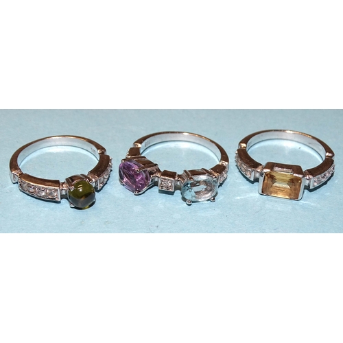 883 - A set of three 14ct white gold stacking rings set blue topaz, amethyst, citrine, tourmaline and synt... 