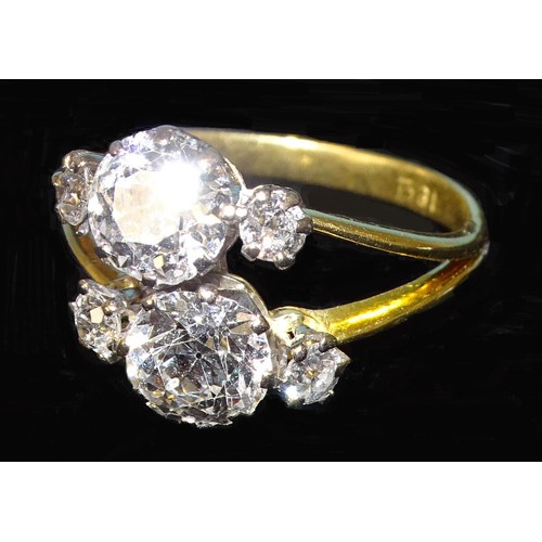 927 - A diamond ring asymmetrically-claw-set two old brilliant-cut diamonds, one approximately 1.29cts, th... 