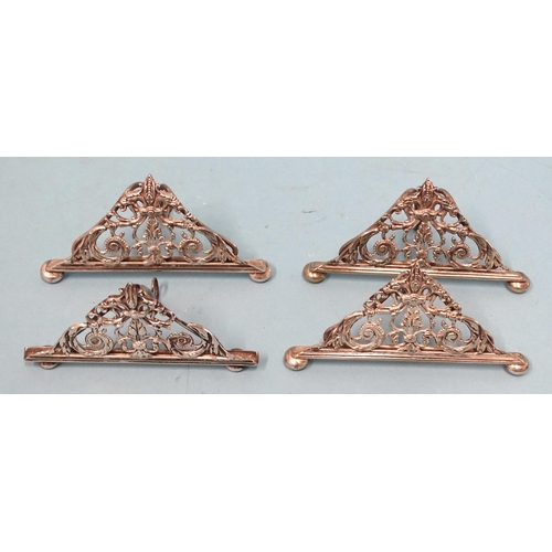 64 - A silver menu holder of triangular pierced scrolling form, on bun feet, 5cm high, 10cm wide, maker W... 