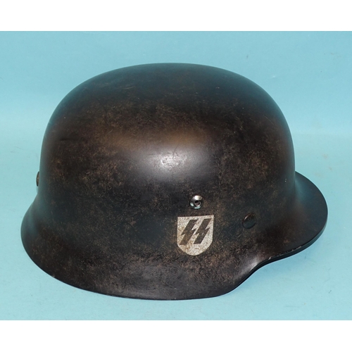 553 - A WWII-era Nazi German SS M35 helmet, with SS rune and swastika decals, the leather liner ink-stampe... 