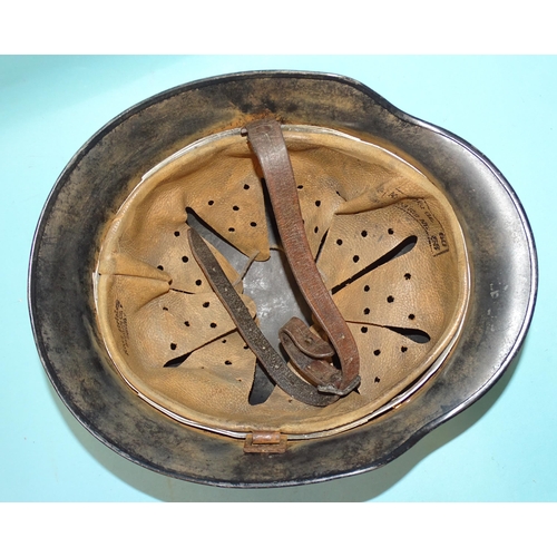 553 - A WWII-era Nazi German SS M35 helmet, with SS rune and swastika decals, the leather liner ink-stampe... 