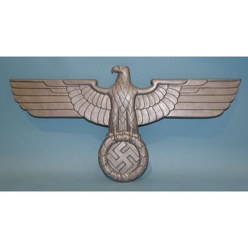 554 - A WWII Third Reich cast alloy eagle and swastika insignia, incised on reverse HE (monogram) G AL Mg ... 