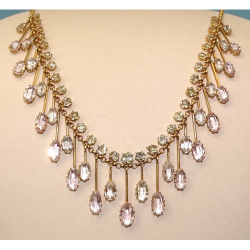 An Edwardian fringe necklace of thirty-one graduated alternate aquamarine and pink topaz drops on knife edge bars, each below a cushion-shaped pale green chrysoberyl, on fine belcher-link gold chain with hook clasp, fringe 17cm long, overall length 37.8cm.