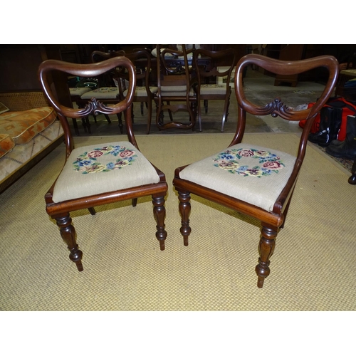 7 - A set of eight Victorian balloon-back dining chairs with drop-in seats, on turned and carved legs.... 