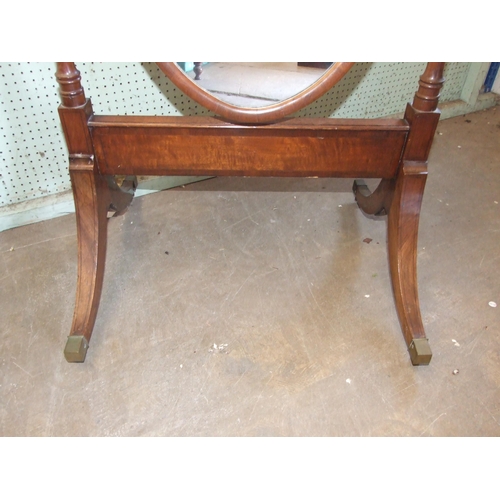 46 - An early-19th century mahogany cheval mirror, the long oval plate within turned columns of swept end... 