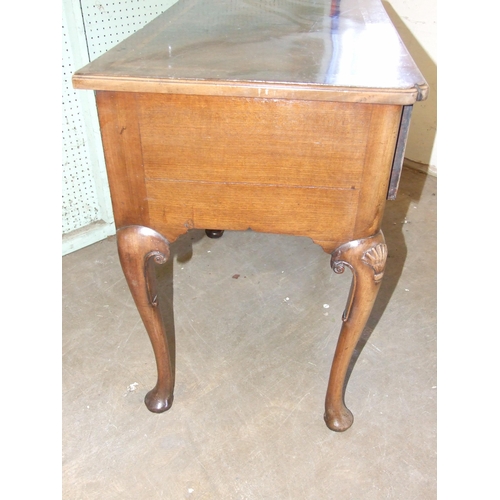 49 - An antique walnut lowboy, the crossbanded top above three drawers, on shell-carved cabriole legs, 79... 